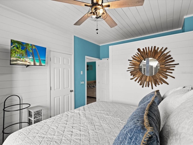 bedroom with ceiling fan, wood walls, and wood ceiling