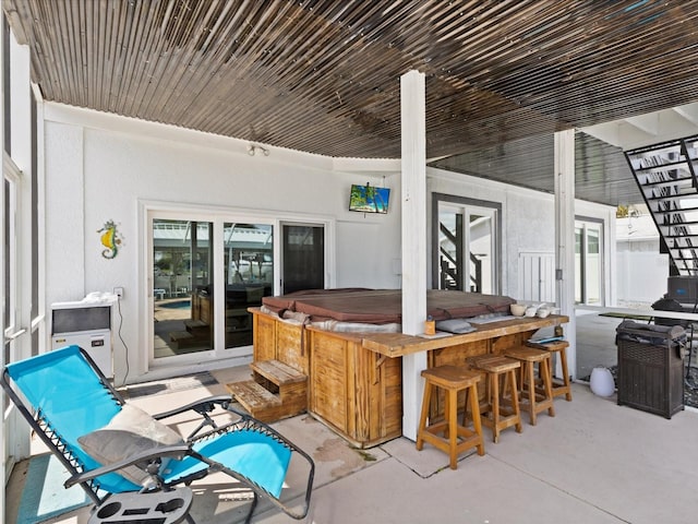 view of patio / terrace with an outdoor bar and a hot tub