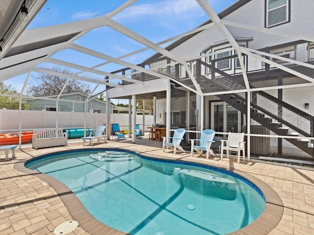 view of pool featuring a lanai, a patio area, and an outdoor bar