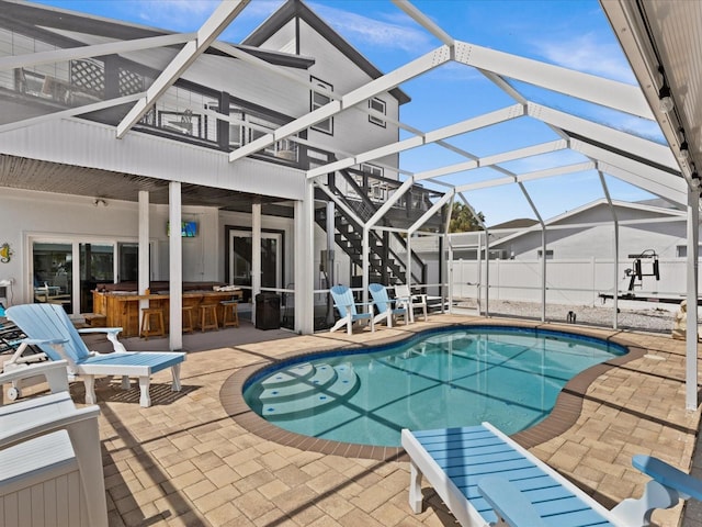 view of pool with a lanai, an outdoor bar, and a patio