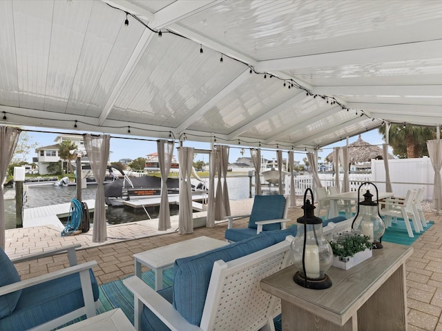 sunroom / solarium with a water view and vaulted ceiling