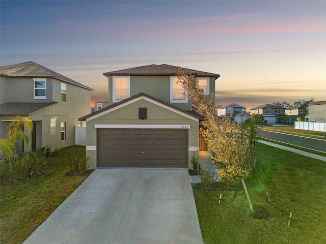 view of front of house featuring a garage and a yard