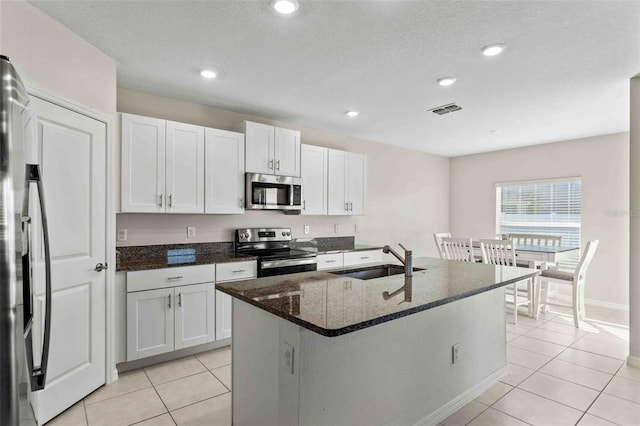 kitchen featuring a kitchen island with sink, white cabinetry, sink, and stainless steel appliances