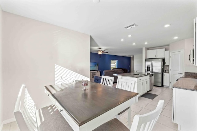 tiled dining room featuring ceiling fan and sink