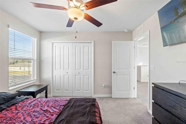 carpeted bedroom with ceiling fan and a closet