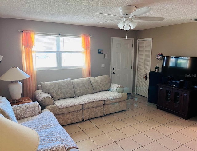 tiled living room with a textured ceiling and ceiling fan