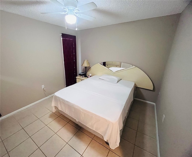 bedroom with tile patterned floors, ceiling fan, and a textured ceiling