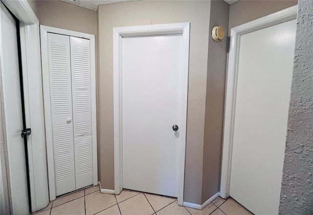 hall featuring light tile patterned flooring