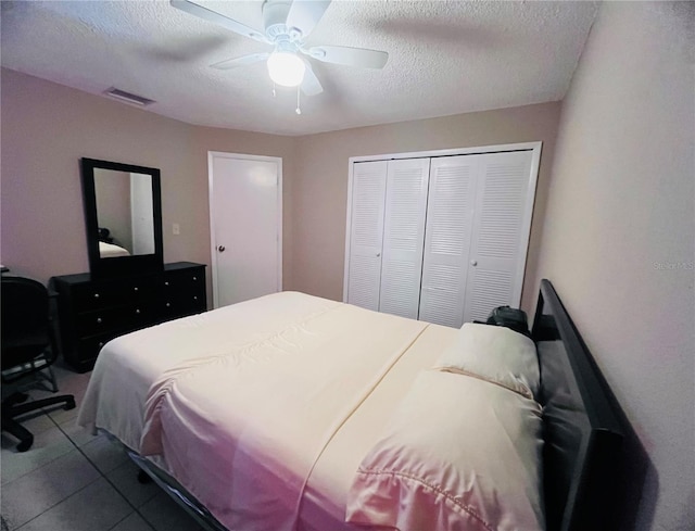 bedroom featuring tile patterned flooring, a textured ceiling, a closet, and ceiling fan