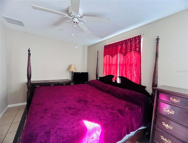 bedroom featuring tile patterned flooring, ceiling fan, and a textured ceiling