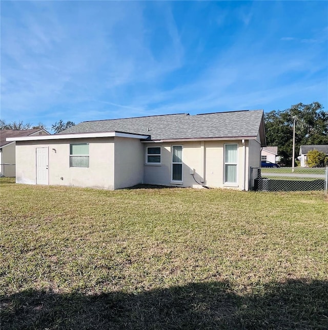 rear view of property with a lawn