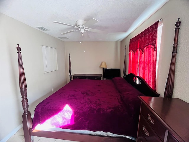 tiled bedroom featuring a textured ceiling and ceiling fan