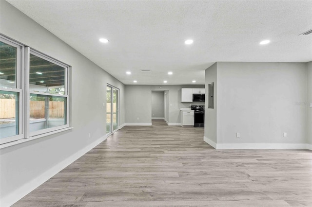 unfurnished living room featuring a textured ceiling and light hardwood / wood-style flooring