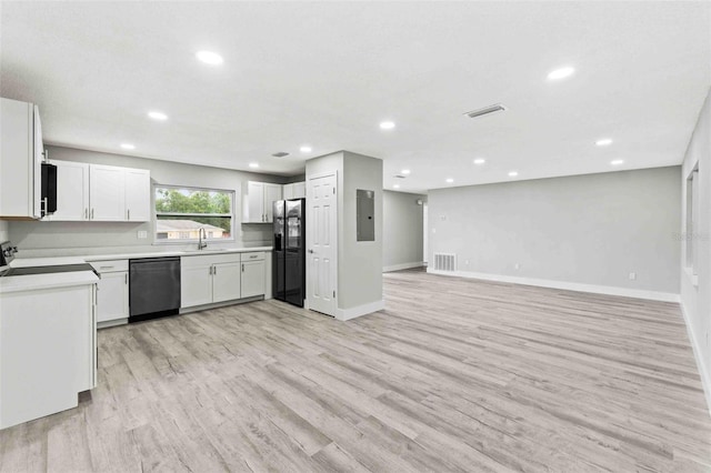 kitchen with sink, electric panel, light hardwood / wood-style floors, white cabinets, and black appliances