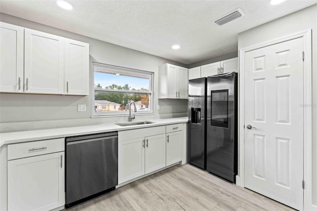 kitchen with white cabinets, sink, light hardwood / wood-style flooring, stainless steel dishwasher, and black fridge with ice dispenser