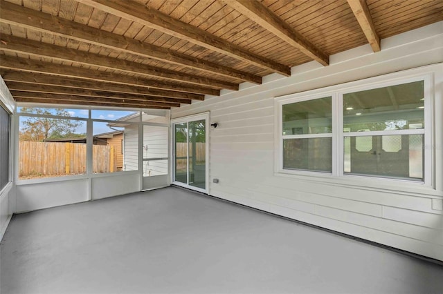 unfurnished sunroom featuring beam ceiling and wood ceiling