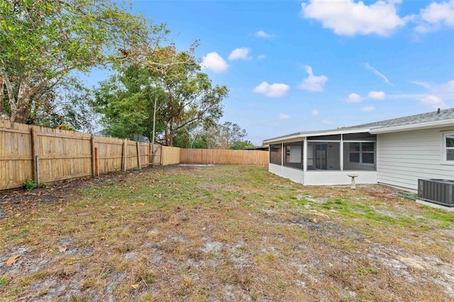 view of yard featuring a sunroom and central AC