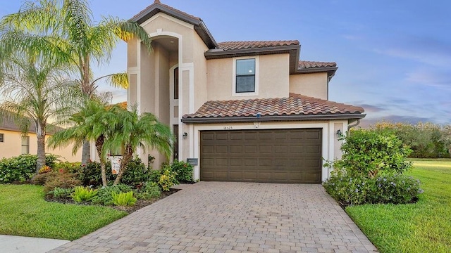 mediterranean / spanish home with a front yard and a garage