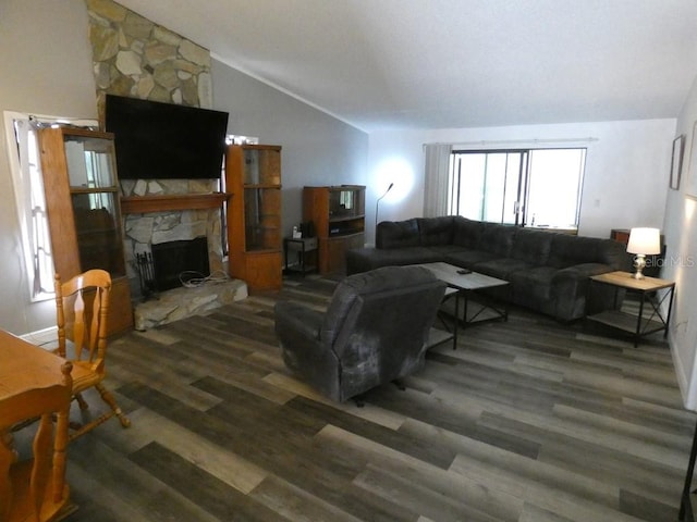 living room with a stone fireplace, dark wood-type flooring, and vaulted ceiling