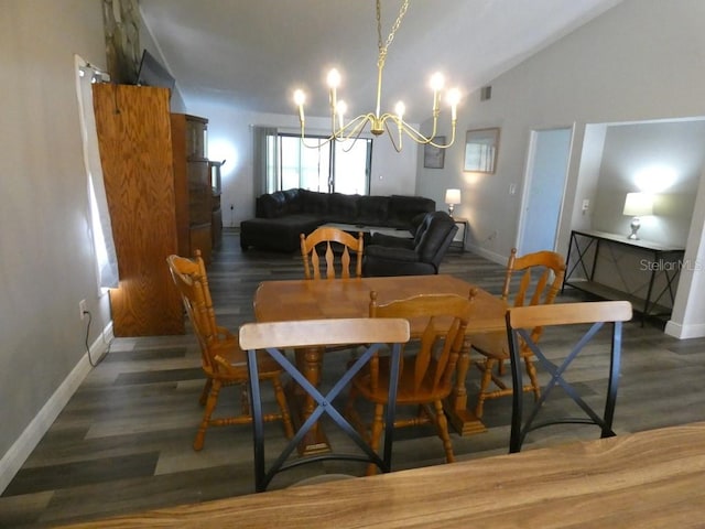 dining area featuring dark hardwood / wood-style flooring, vaulted ceiling, and a notable chandelier