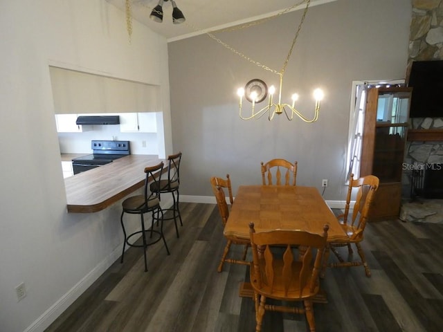 dining space with dark hardwood / wood-style flooring, high vaulted ceiling, and an inviting chandelier