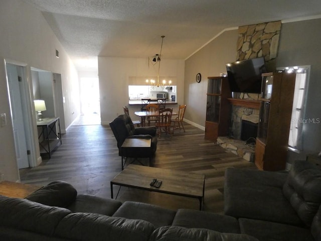 living room featuring high vaulted ceiling, hardwood / wood-style flooring, a textured ceiling, a fireplace, and a chandelier