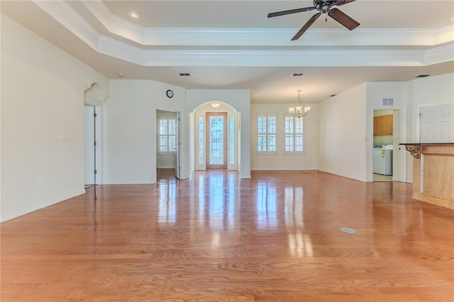 unfurnished living room with ceiling fan with notable chandelier, light hardwood / wood-style flooring, and crown molding