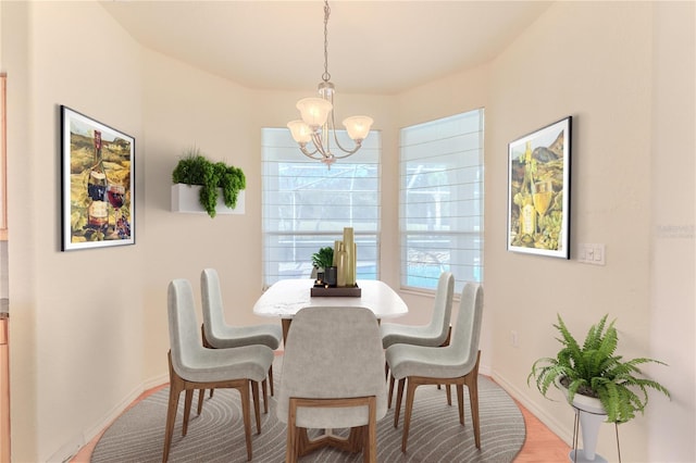 dining room featuring hardwood / wood-style flooring and an inviting chandelier