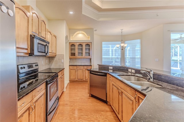 kitchen featuring plenty of natural light, crown molding, sink, and appliances with stainless steel finishes