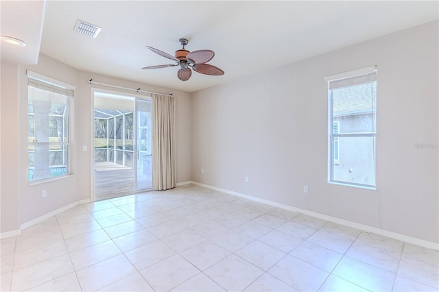 tiled spare room featuring ceiling fan