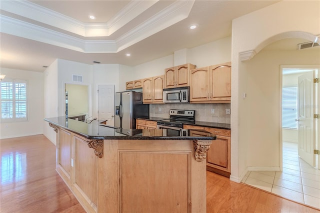 kitchen featuring tasteful backsplash, crown molding, stainless steel appliances, and light wood-type flooring