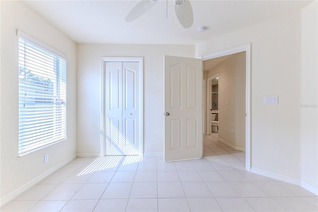 unfurnished bedroom with ceiling fan, a closet, and light tile patterned floors