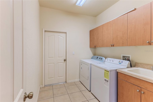 laundry area with sink, cabinets, independent washer and dryer, a textured ceiling, and light tile patterned floors