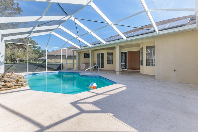 view of swimming pool featuring a patio area, ceiling fan, and glass enclosure