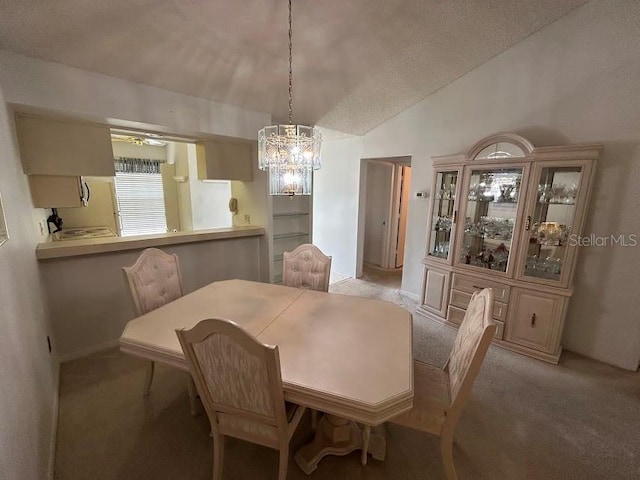 dining area featuring a textured ceiling, a chandelier, light colored carpet, and lofted ceiling