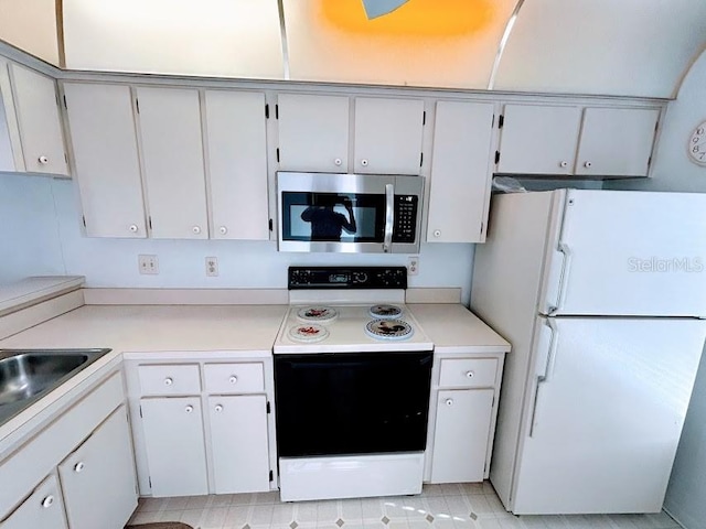 kitchen with white cabinets, white appliances, and sink