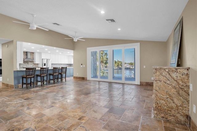 living room with ceiling fan and vaulted ceiling