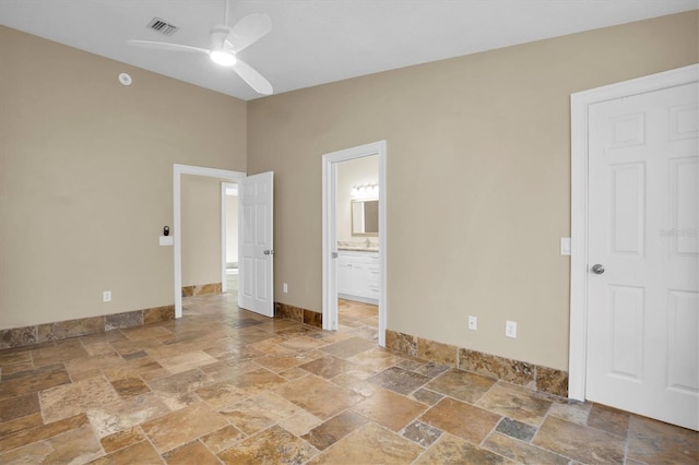 unfurnished bedroom featuring ceiling fan and ensuite bathroom