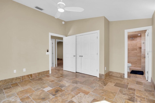 unfurnished bedroom featuring a closet, ensuite bathroom, and ceiling fan