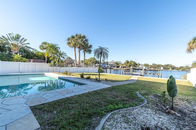 view of swimming pool featuring a lawn, a water view, and a dock