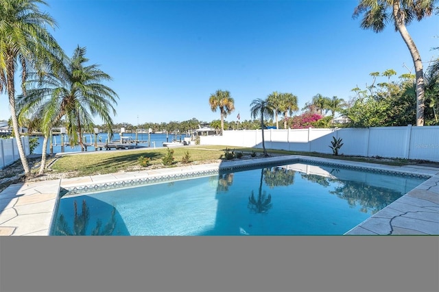 view of pool with a yard and a water view