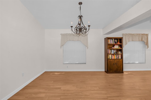 unfurnished dining area featuring light hardwood / wood-style floors and an inviting chandelier