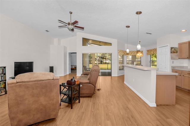 living room with light hardwood / wood-style floors, vaulted ceiling, and ceiling fan