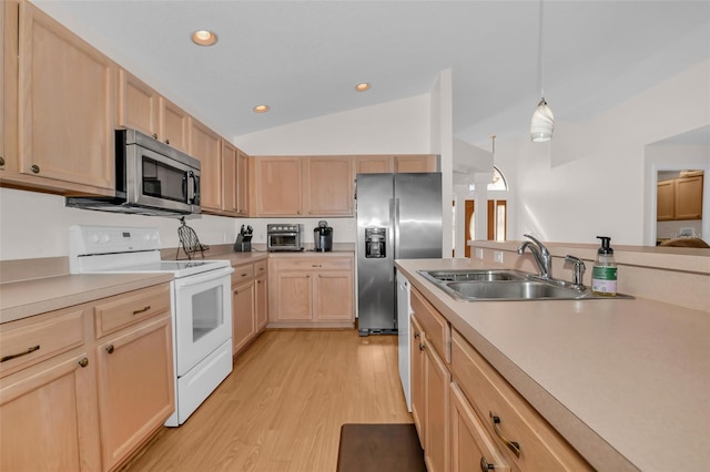 kitchen with light brown cabinetry, stainless steel appliances, light hardwood / wood-style floors, hanging light fixtures, and lofted ceiling