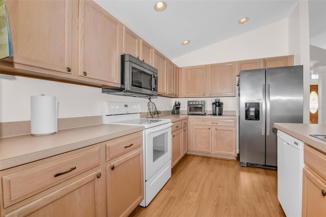 kitchen featuring light brown cabinetry, stainless steel appliances, lofted ceiling, and light hardwood / wood-style floors