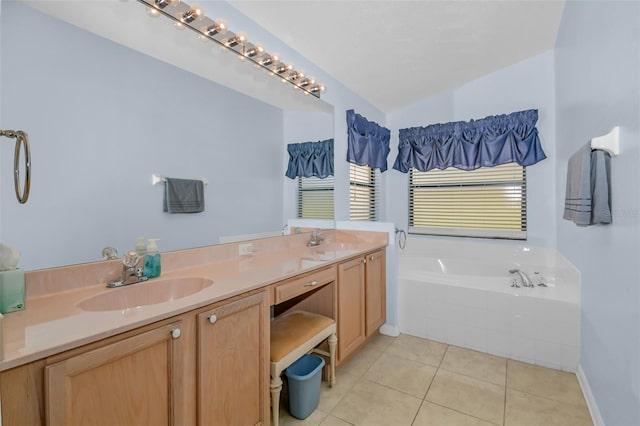 bathroom featuring tile patterned floors, vanity, and tiled bath