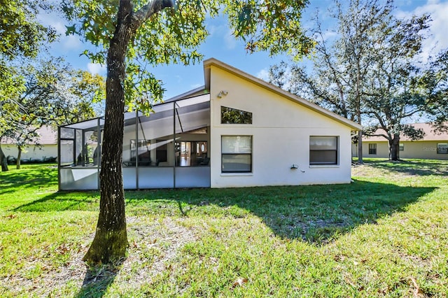 back of property with a yard and a lanai