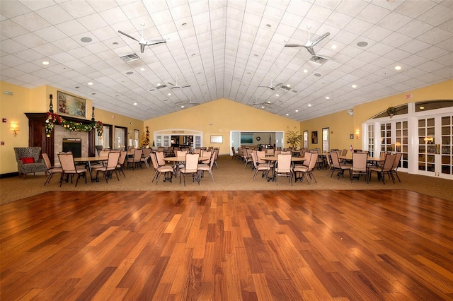 unfurnished dining area featuring hardwood / wood-style floors, high vaulted ceiling, and ceiling fan