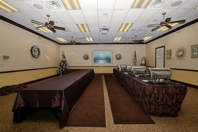 cinema room featuring carpet, a paneled ceiling, and ornamental molding