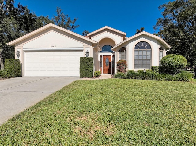 view of front of home with a garage and a front lawn